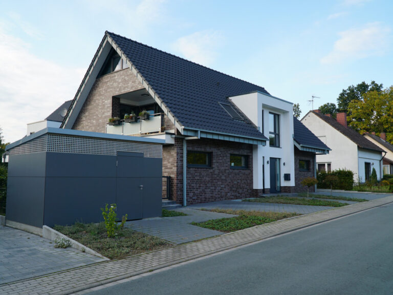 Alleinstehendes Haus mit dunklem Klinker und gepflasterter Auffahrt.