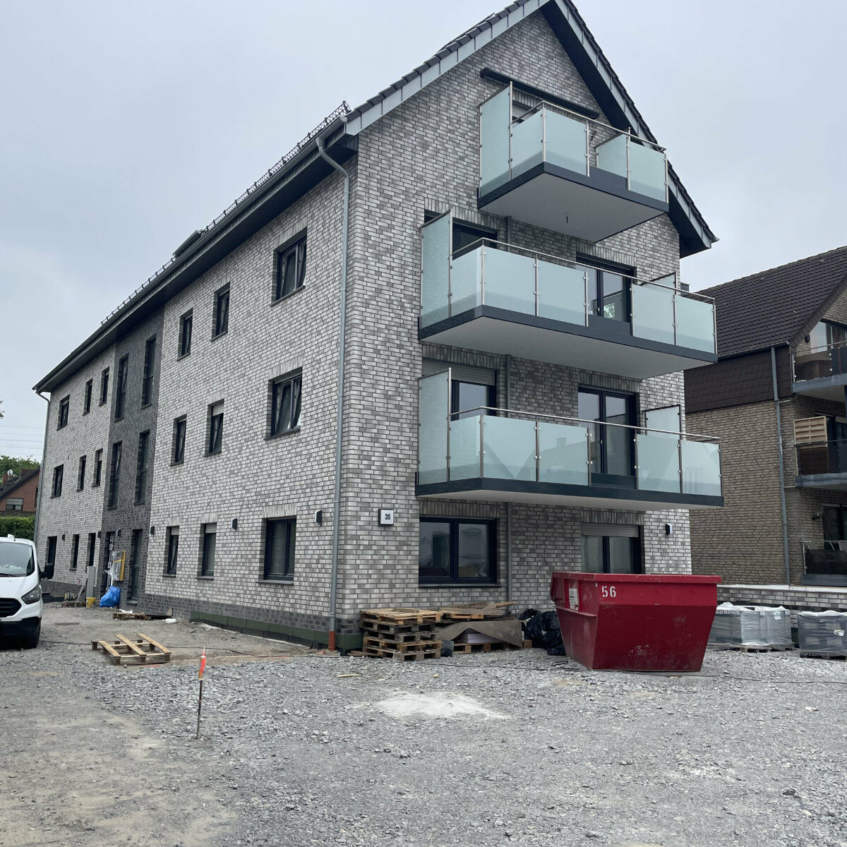 Mehrstöckiges Wohnhaus mit Balkonen.