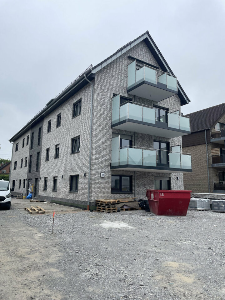 Mehrstöckiges Wohnhaus mit Balkonen.