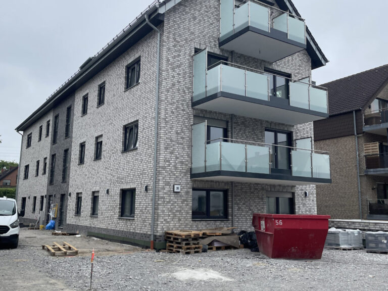 Mehrstöckiges Wohnhaus mit Balkonen.