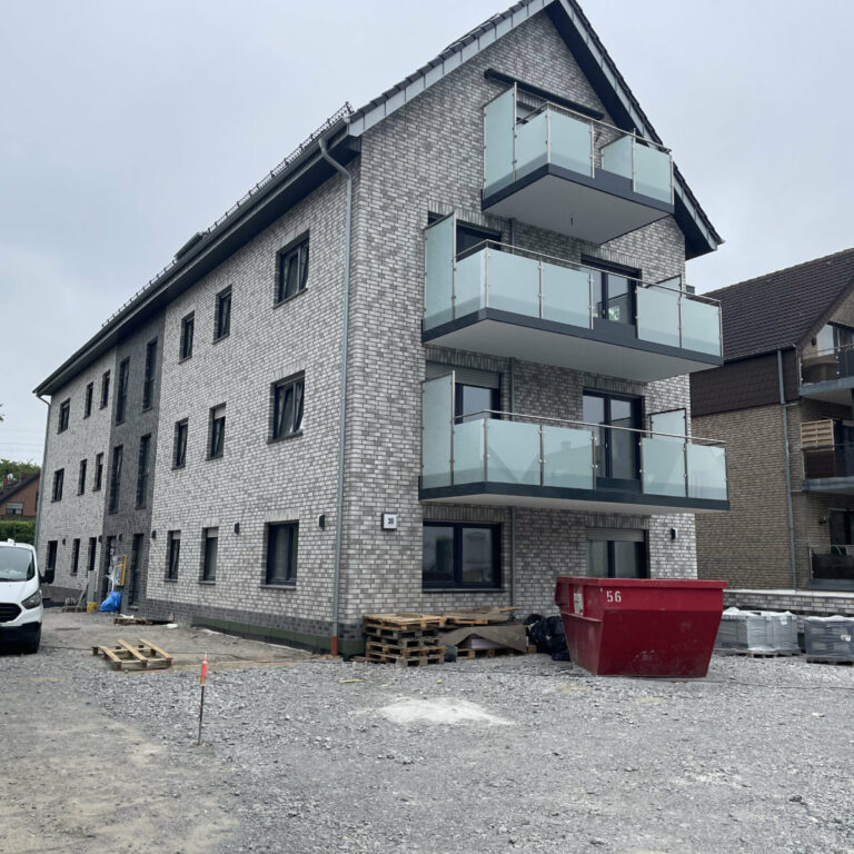 Mehrstöckiges Wohnhaus mit Balkonen.