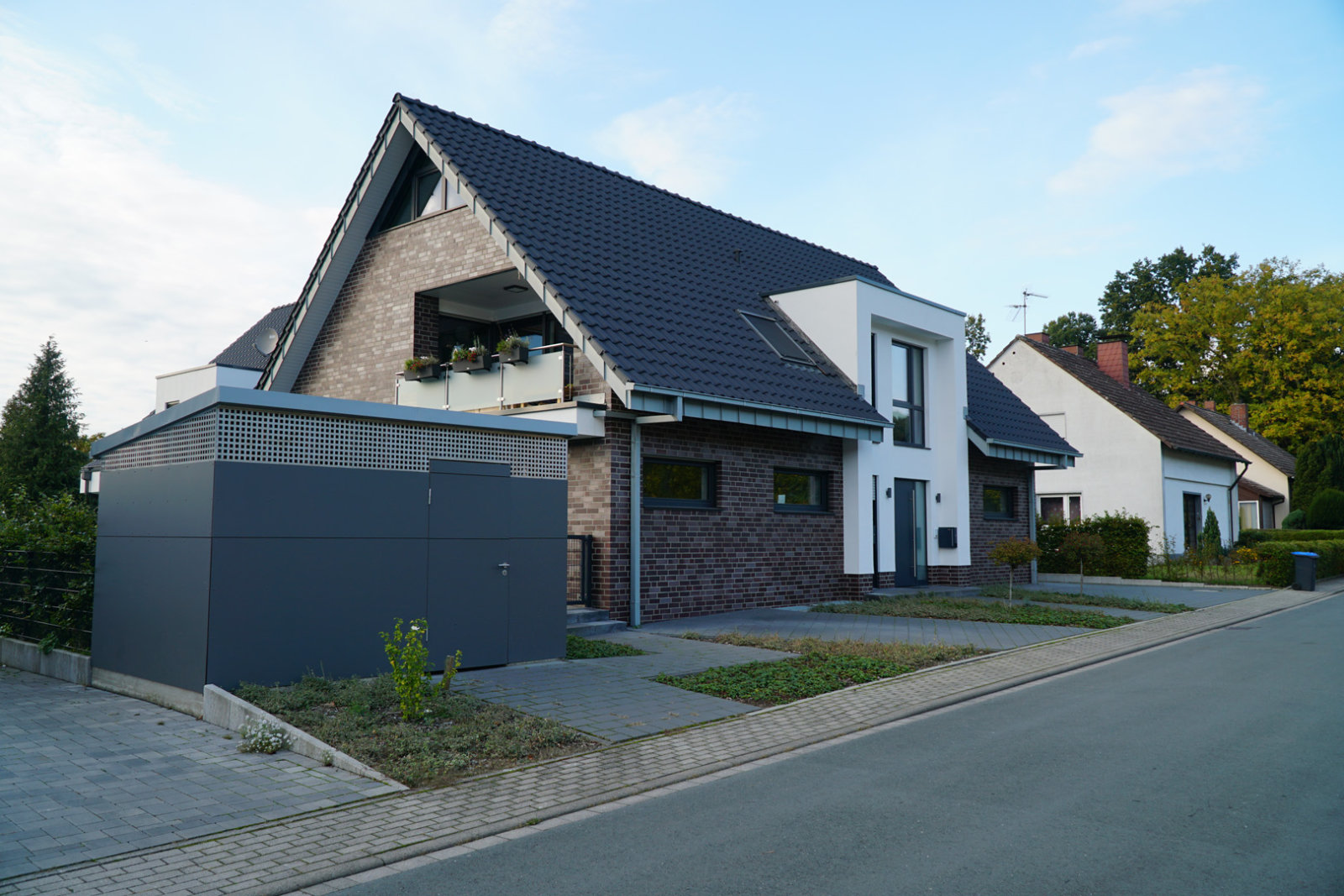 Alleinstehendes Haus mit dunklem Klinker und gepflasterter Auffahrt.