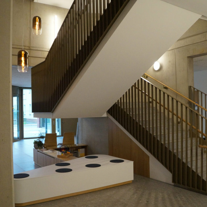 Moderner Treppenaufgang mit dunklen Stufen.