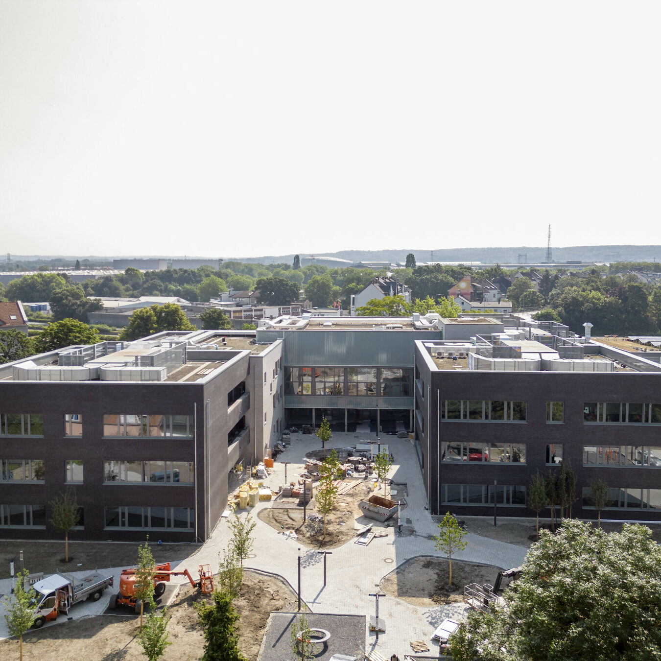 Frontalansicht zweier Schulkomplexe in der Bauphase.