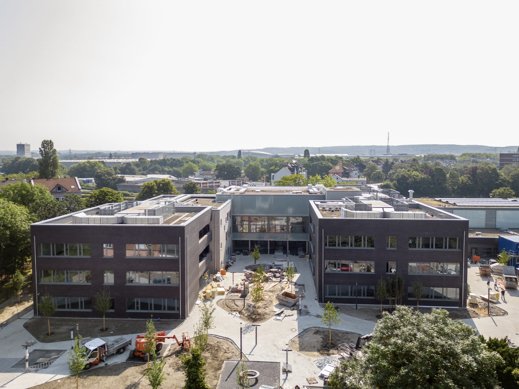 Frontalansicht zweier Schulkomplexe in der Bauphase.