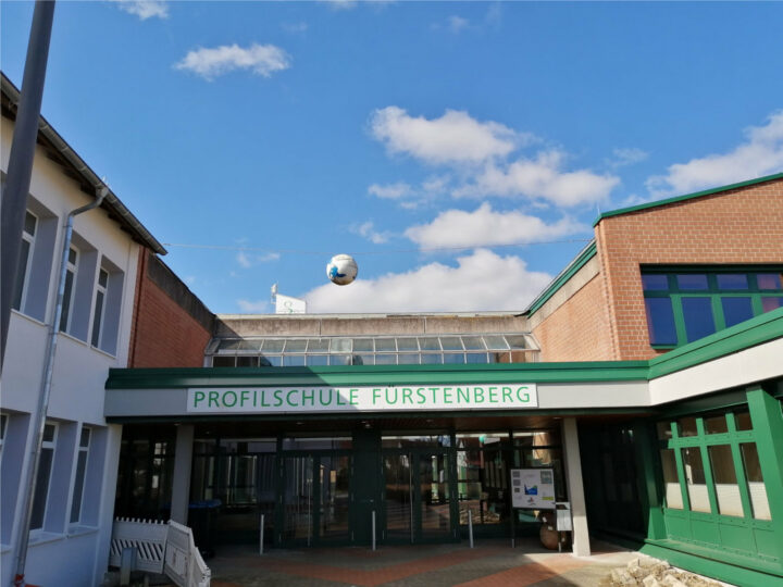 Rotes Backsteingebäude mit grünen Fenstern und der Aufschrift Profilschule Fürstenberg.